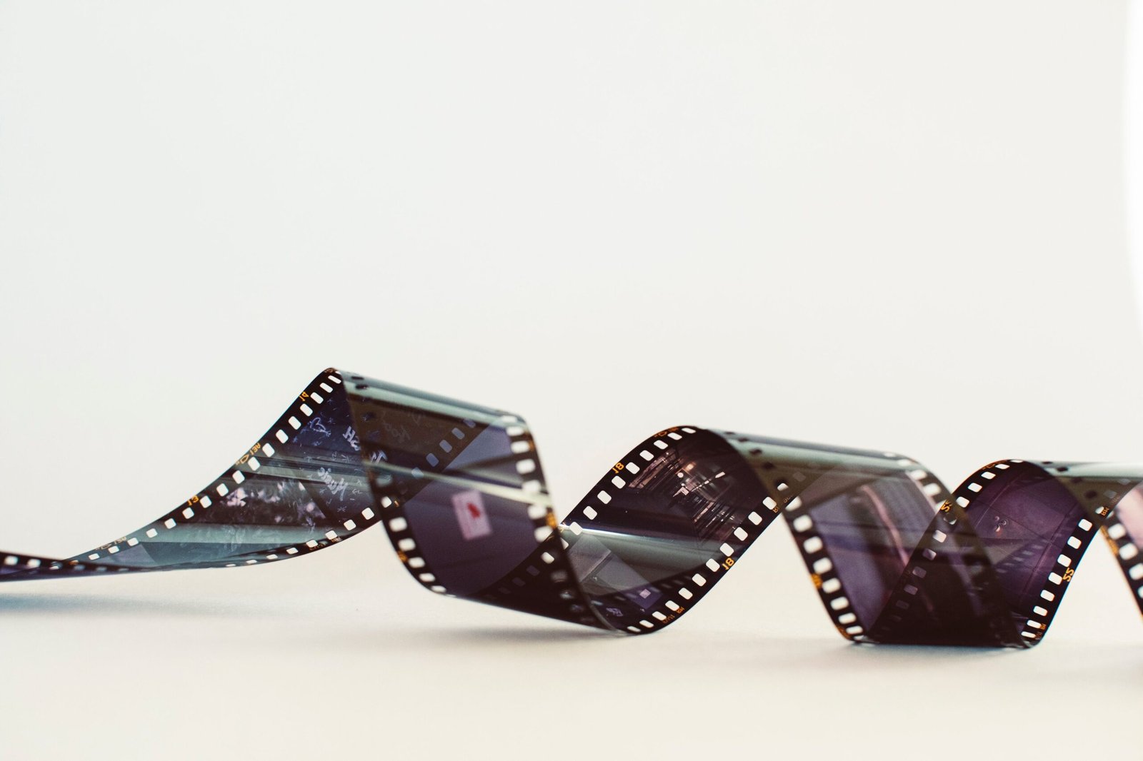 Close-up of a classic photographic film strip with a vintage feel against a white background.